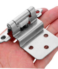 Hand holding self-closing recessed cabinet hinge showing metal durability and design.
