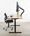 Built Tough VESA Adapter Bracket For TVs And Monitors Max 42 Inches on a desk with a monitor, plant, and black chair.