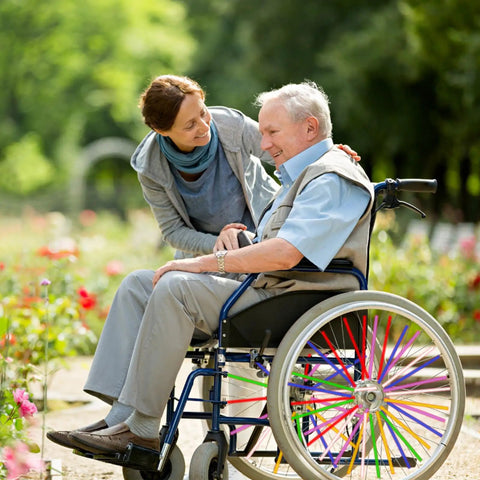 Wheelchair with 180 Pcs Spoke Skins And Covers In 10 Dope Color Mix for decoration and protection in a garden setting