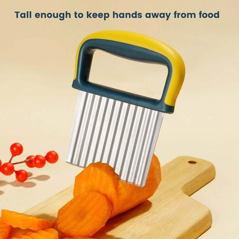 Crinkle cutter knife with yellow and teal handle and stainless steel blade cutting carrot slices on wood cutting board.