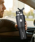 Smooth Operator 40oz Stainless Steel Vacuum Insulated Water Bottle With Straw And Spout Lids Kept Ice Cold For Two Full Days Fits Every Car Cup Holder For Weekend Drifts Summer Vibes And Travel Black in hand inside car.