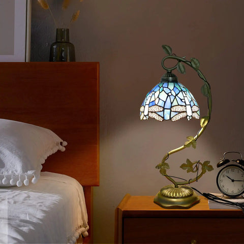 Sea Blue Dragonfly Handmade Stained Glass Desk Lamp with Metal Leaf Base beside bed in dimly lit room