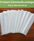 10 individually packaged sheets of 9x12 Feet Disposable Painter Drop Cloths With Gloves, Waterproof Anti Dust Clear Tarp displayed on wood.