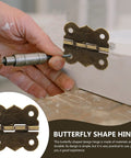 Close-up of installing Antique Bronze Mini Hinges Set 40 Pieces 30x27mm on wooden surface using a screwdriver