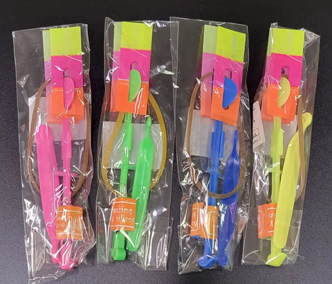 Pack of 12 Cool LED Light Up Helicopters Slingshot Flying Toys in multicolor, packaged in clear bags for outdoor play.