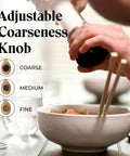Adjustable coarseness knob on Must-Have Salt and Pepper Grinder Set With Stand, Glass Body Grinders, in use over a bowl.