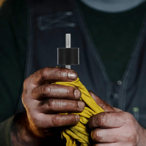 Four Piece Built For The Grind Anti Vibration Rubber Studs M10 Double Screw Mount held with yellow cloth in a hand.