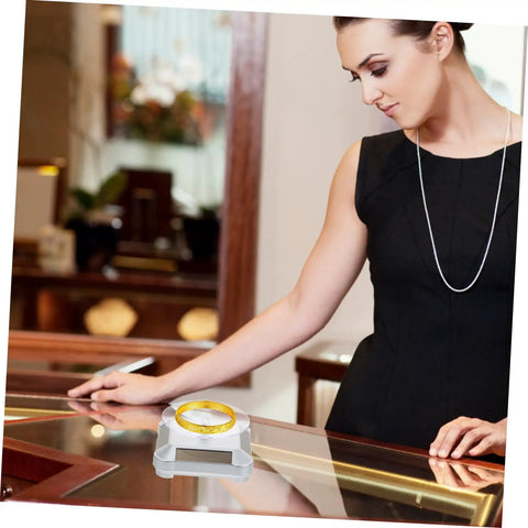 Galpada Solar Powered Jewelry Display Stand With Electric Rotating Turntable For Bracelets And Watches Plus Earrings Store Office Counter Shelf Rack Natural Light Battery Backup Smooth Spin Showcase with a ring on it.