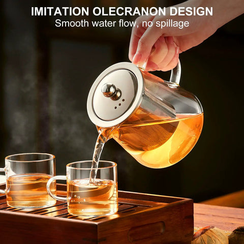 Pouring tea from a Stovetop Safe Glass Teapot 550ml with Removable Stainless Steel Infuser, borosilicate glass, into two cups.