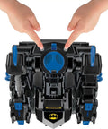 DC Super Friends RC Transforming Bat Bot 2-Foot Tall Robot with Lights And Sounds remote control, top view with child hands.