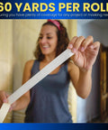 Person holding Beige Painter Tape For Crisp Lines And Trim, 0.7 Inch By 60 Yards, Thin Low Residue Masking Tape indoors.