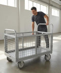 Beefed Up Heavy Duty Flatbed Wire Mesh Cart With Dual Handles And High Fence Sturdy Steel Construction Four Swivel Industrial Wheels Easy Haul For Steel Plates Up To 100 By 60 Heavy Load Trolley with man in workshop