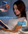 Woman controlling Smart Outdoor String Lights 48 Feet With 16 Shatterproof LED Bulbs via Alexa in bedroom scene