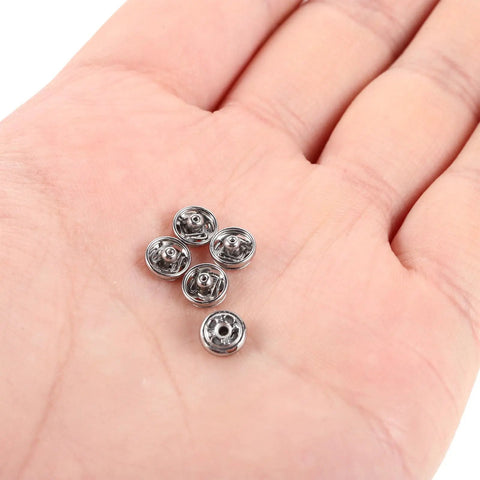 Hand holding 120 Pcs Silver Metal Snap Fasteners 6mm Mini Sew On Button Closures For Clothes Dolls Garments DIY Sewing Accessories