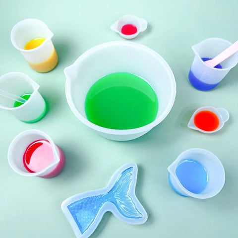 Ultimate Resin DIY Kit Silicone Measuring Cups Set With 600ml And 100ml Mixing Cups and colorful epoxy mix in molds.