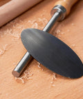 Top Shelf Six Piece Cabinet Scraper And Burnisher Kit With Blue Spring Steel Blades Plus Hardened High Speed Steel Sharpening Rod For Knockout Woodworking Finishes Daily, steel scraper blade on wooden surface.