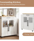 Farmhouse Mobile Kitchen Island Cart With Slick Rolling Lockable Casters And Front Glass Cabinet Plus Roomy Gear Hauler Drawer And Three Tier Spice Shelf For Weekend Cookoffs in white with wood top and glass doors.