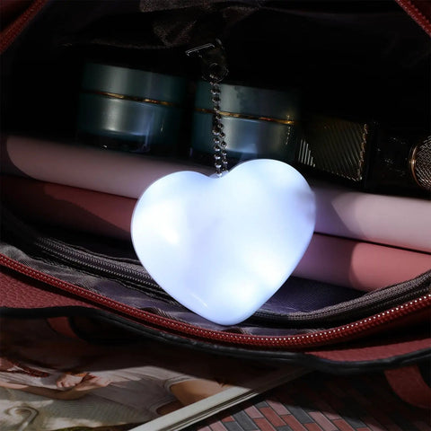 Illuminated heart-shaped purse light inside a handbag, part of Two Pack Heart Shape Purse Lights With Sensor Illuminator For Handbags.