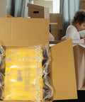 Air Pillows For Shipping With Pump Pack Of 400 Count Inflatable Packing Air Bags Alternative To Packing Peanuts 3.54 By 7.87 Inches No Air Cushion Machine Needed Easy Inflate Keeps Items Protected displayed in open cardboard box, with child playing in background.