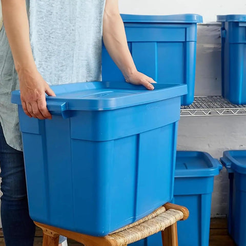 Person carrying a Heavy Duty Stackable Storage Bin 18 Gallon Plastic Tote With Lids And Handles Heritage Blue.