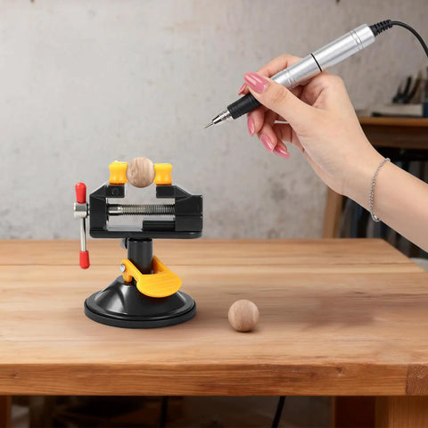 Portable Aluminum Alloy Drill Press Vise With Suction Base, Table Bench Clamp For Jewelry Making And Hobby Crafts, Small Parts Holding, Mini Workbench Vise For Workshop, Lightweight Yet Rugged And Easy Mount. 180° base on wooden table holding a small ball