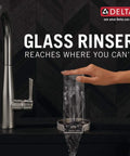Hand using Chrome Glass Rinser For Kitchen Sink GR250 with powerful water jets on clear glass in modern kitchen.