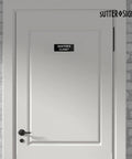 Durable ABS Door Sign with Full Adhesive Backing 2x6 Inch installed on door labeled 'Janitor's Closet'