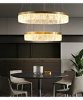 Next Level Gold Round Pendant Light Featuring Three Color Adjustable Aluminum Shade For Smooth Eye Friendly Illumination above a dining table.