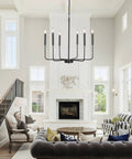 Black 6 Light Farmhouse Chandelier With Industrial Iron Vibe For Dining Room Living Room Kitchen Island And Foyer, Adjustable Height Chain Up To 66.9 Inches, Modern Rustic Ceiling Lighting Fixture in a spacious living room setting.