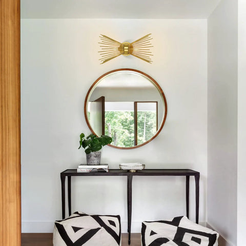 Antique Brass Two Light Modern Mid Century Wall Sconce in a stylish living room with a round mirror and black console table.