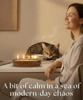 Woman smiling at desk with Sand Candle Kit With 24 Wicks And Ivory Pearled Wax Beads 1 Pound Includes Wood Holder, cat resting