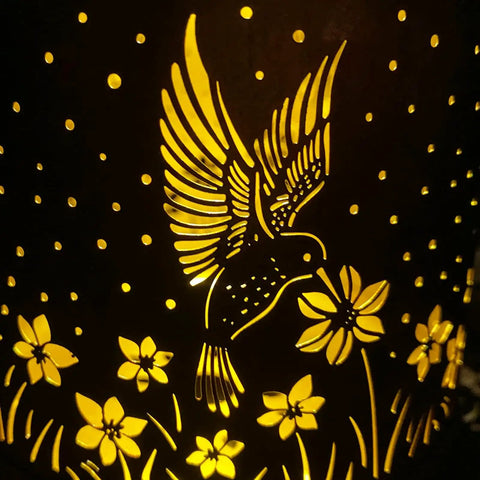 Outdoor Solar Lantern With Hummingbird Pattern, Waterproof Metal Garden Light with glowing floral and bird cutouts on bronze metal