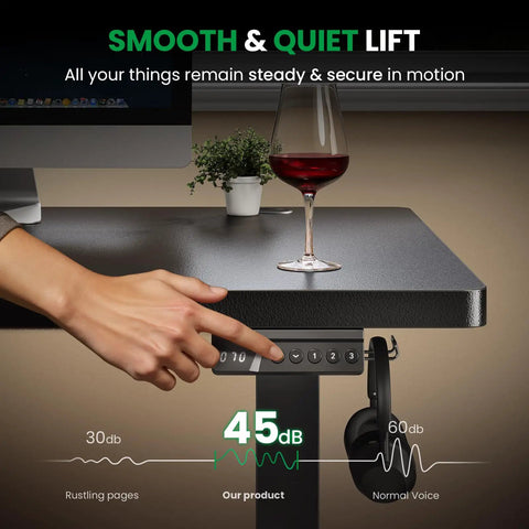 Electric Standing Desk 60x28 Inch Sit Stand Desk With 1 Inch Thick Top being adjusted with wine glass and plant on top.