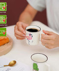 Person holding a Four Pack Ceramic Demitasse Espresso Cup, 4.23 Oz Small Coffee Mugs For Espresso Machines And Home Coffee Makers.