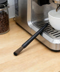 Cleaning brush on espresso machine in kitchen setup