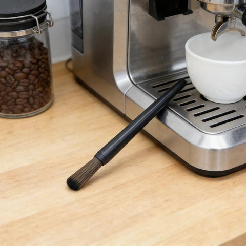 Cleaning brush on espresso machine in kitchen setup