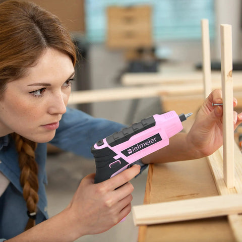 Woman using Pink Cordless Screwdriver Set With Automatic Torque Control And Sensor for light DIY home repair and assembly.