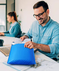 Person placing documents into Blue Large Bubble Mailers 12x16 Inch 25 Pack Usable 12x15 Inch Self Seal Padded Envelopes Waterproof Heavy Duty