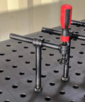 Close-up of 4-Pack 180 Degree Welding Fixture Screw Clamps For Five Eighth Inch Tables installed on a fixture table