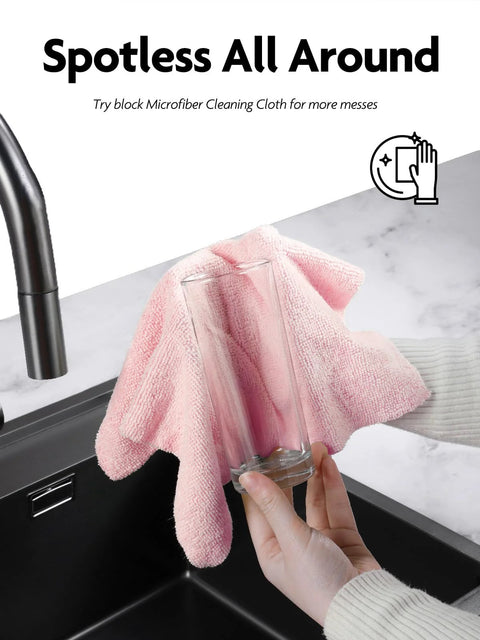 Fantasticlean pink microfiber cleaning cloth in use, wiping a glass at a kitchen sink