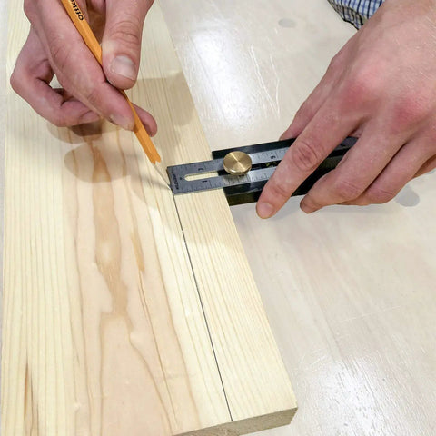 Using Straight Shooter Nine In One Measuring And Marking Tool Featuring Dual Levels Sliding Bevel to mark wood.