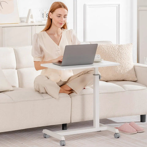 Woman using Mobile Standing Desk On Wheels, Sit Stand Laptop Table With Lockable Casters, Adjustable 7 Level Height, White