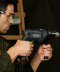 Man using Pro-Grade 5 Amp Half Inch Hammer Drill Kit With 105 Accessories, Variable Speed To 3000 RPM, Two-Function Tool