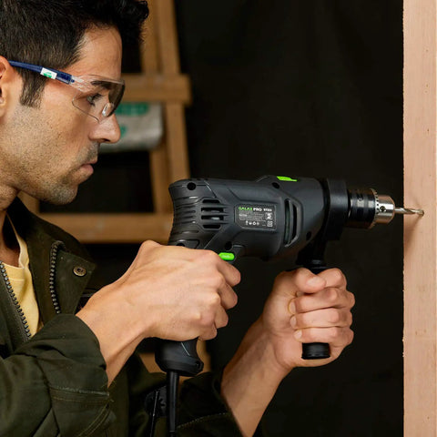 Man using Pro-Grade 5 Amp Half Inch Hammer Drill Kit With 105 Accessories, Variable Speed To 3000 RPM, Two-Function Tool