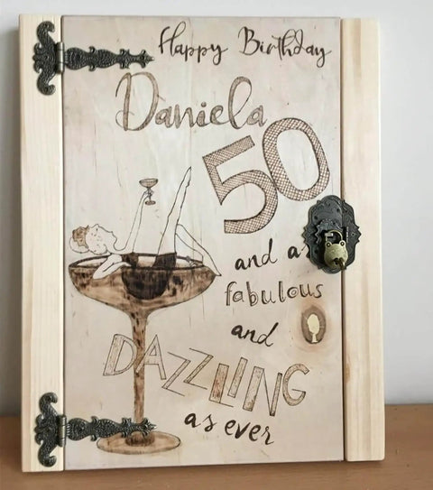 Decorative wooden birthday card with intricate bronze hinges featuring a woman in a martini glass illustration and birthday greetings.