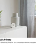 Super Smooth Wireless Smart Motion Sensor 3 Pack Wide Angle Indoor Outdoor Detection No Sweat Setup Works With Apple Home Alexa Google SmartThings Automate Your House Like A Pro Requires Thread Border Router on a shelf next to plant and vase.