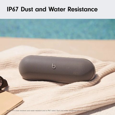 All Day Battery Wireless Bluetooth Speaker With USB C Charging Punchy Bass Up To 24 Hours Of Battery Life IP67 Water Resistant Built In Mic Apple And Android Compatible Dark Gray Portable Party Speaker on towel by pool