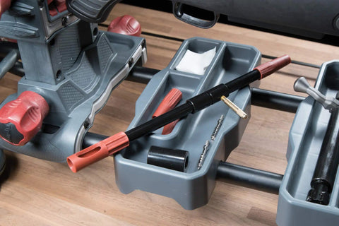 Universal Bore Guide With Three Muzzle Guides on cleaning station tray for firearms maintenance