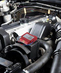Road Ready Automatic Fire Extinguisher, Portable Aerosol Auto Suppression Spray on engine bay, showcasing heavy duty adhesive backing.