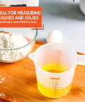 Two Cup Measuring Cup With Clear Ounces And Milliliters Markings For Liquid And Dry Ingredients next to bowl and egg on wooden surface